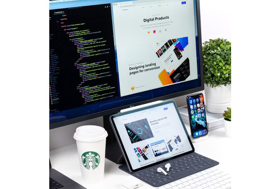 Web developer workstation with code and website designs